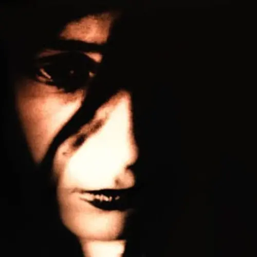 Photo d'un visage de femme partiellement masqué par des ombres