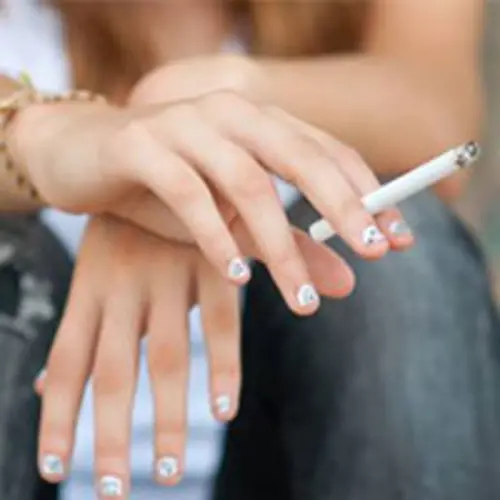 Photo de mains de femme tenant une cigarette