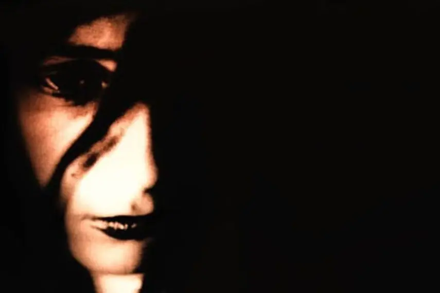 Photo d'un visage de femme partiellement masqué par des ombres