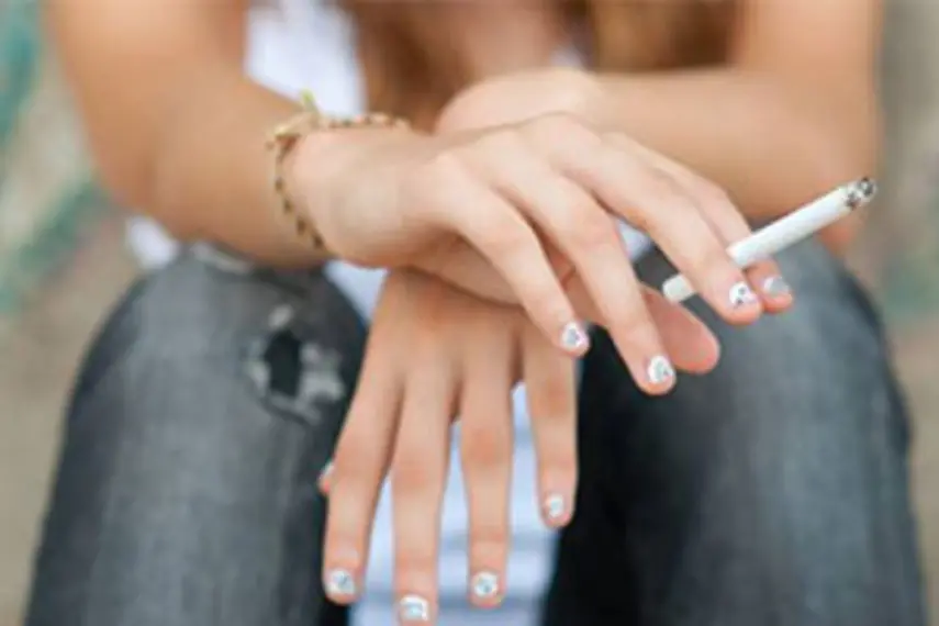 Photo de mains de femme tenant une cigarette