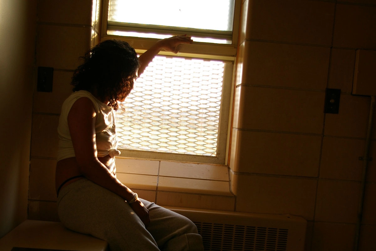 Photo of an incarcerated woman looking out a window